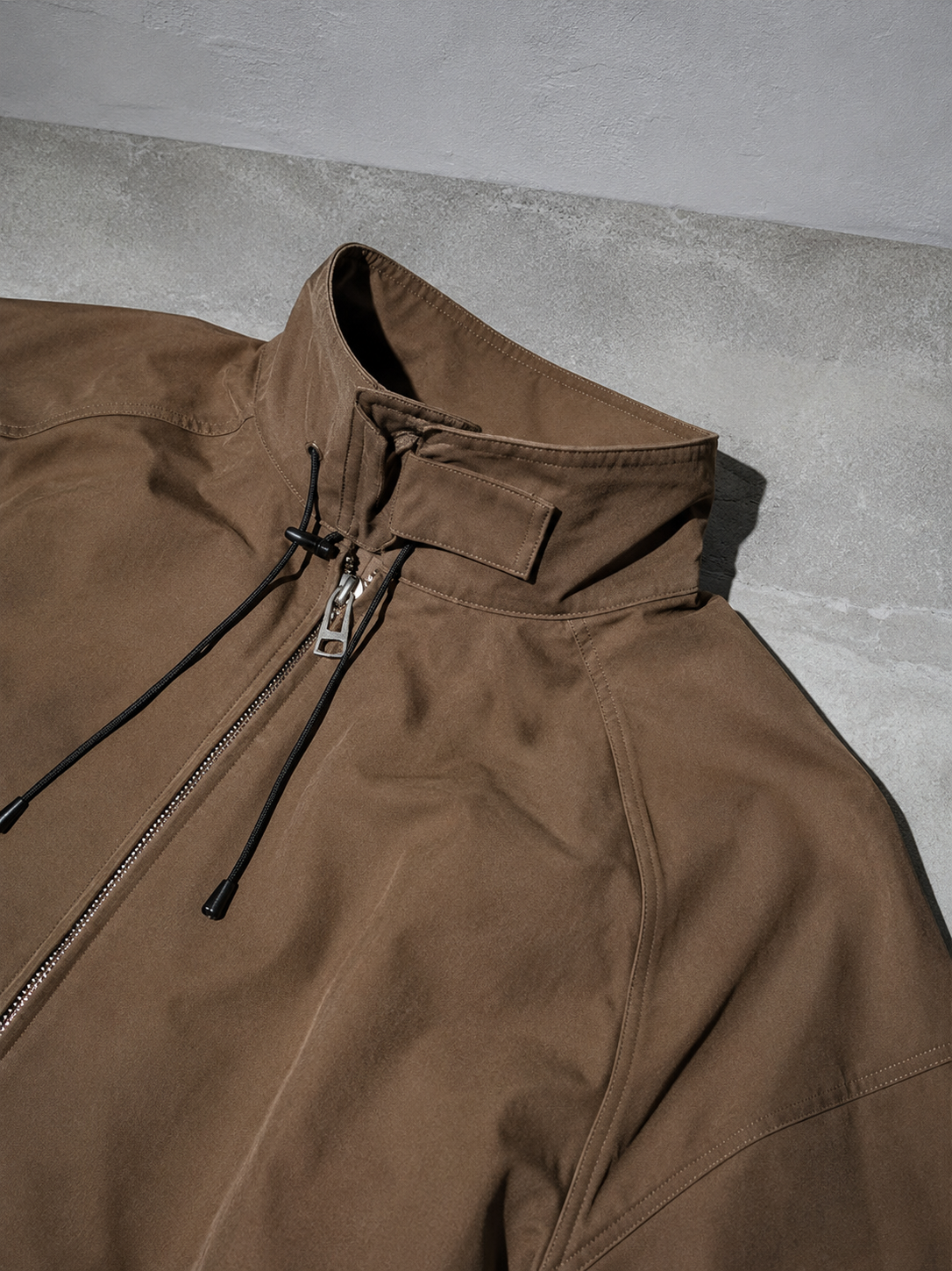 Code Culture catalog | outdoor-shell-jacket-commuting-functional-workwear | color-a003-brown | macro flat lay
