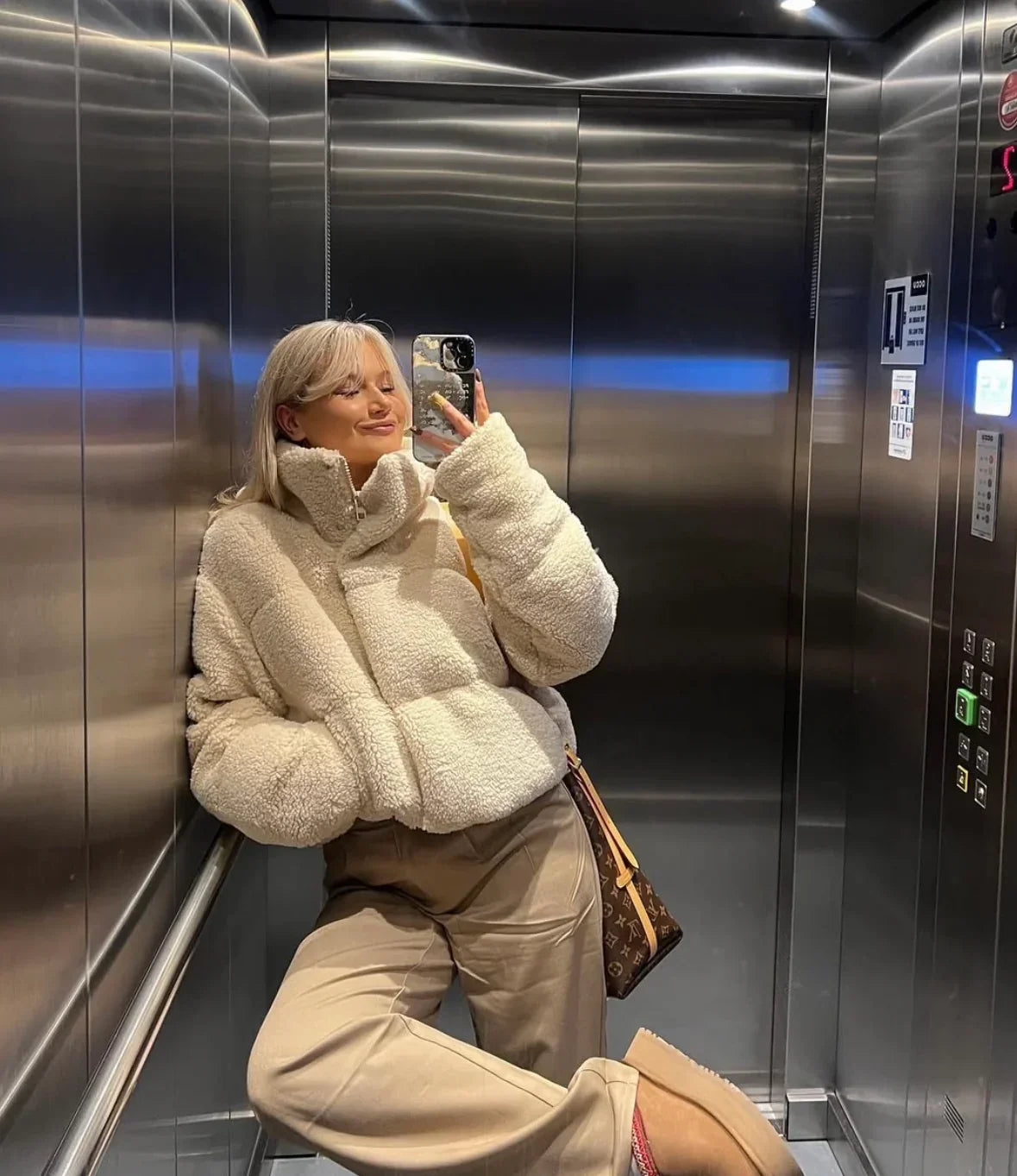 Beige oversized teddy puffer jacket with hooded collar and long sleeves