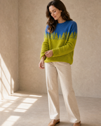 Women's Fashionable Pullover Sweater Top in Chartreuse Forest, adjusting the sleeve, worn by model