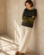 Women's Fashionable Pullover Sweater Top in Green, wall lean, looking down, worn by model