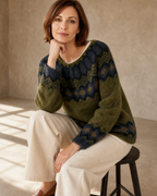 Women's Fashionable Pullover Sweater Top in Green, stool, elbow on knee, worn by model