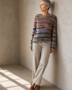 Women's Fashionable Pullover Sweater Top in Rainbow, wall lean, looking to the light, worn by model
