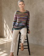 Women's Fashionable Pullover Sweater Top in Rainbow, stool, leaning back on hands, worn by model