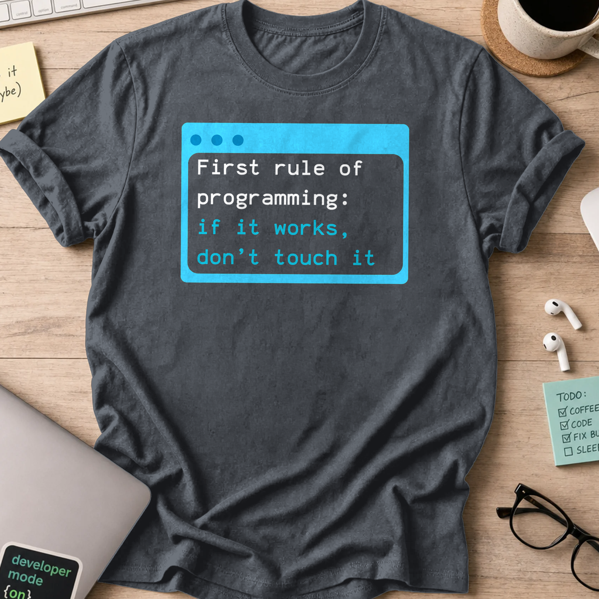 Dark Heather Grey programmer shirt printed with "first rule of programming", a funny developer t-shirt and coding gift for software engineers.