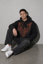 Men's black winged skeleton graphic hoodie seated view