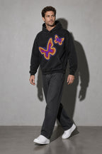Men's black neon butterfly graphic hoodie walking view