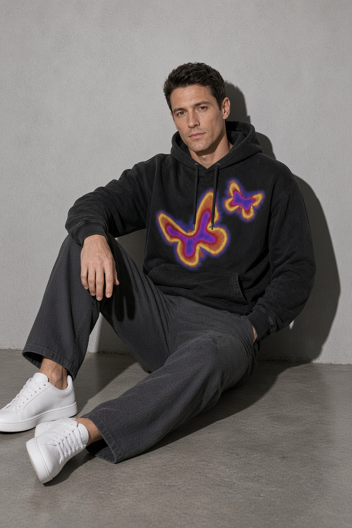 Men's black neon butterfly graphic hoodie seated view