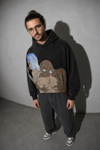 Men's black surrealist figures graphic hoodie standing view