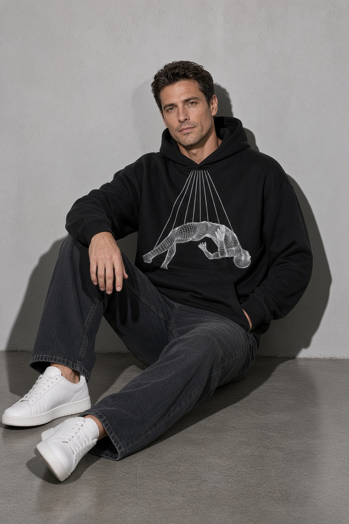 Men's black wireframe figure graphic hoodie seated view