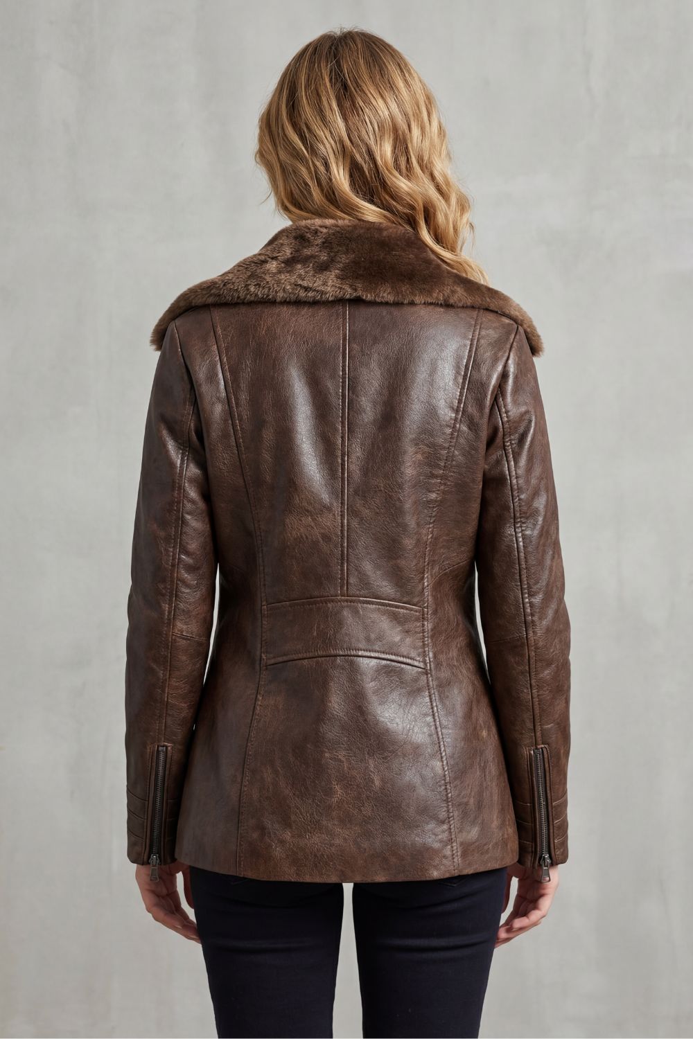 Back view of brown shearling leather jacket with stand collar and seam detailing