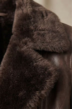 Close-up of brown shearling collar on a leather jacket, soft textured trim