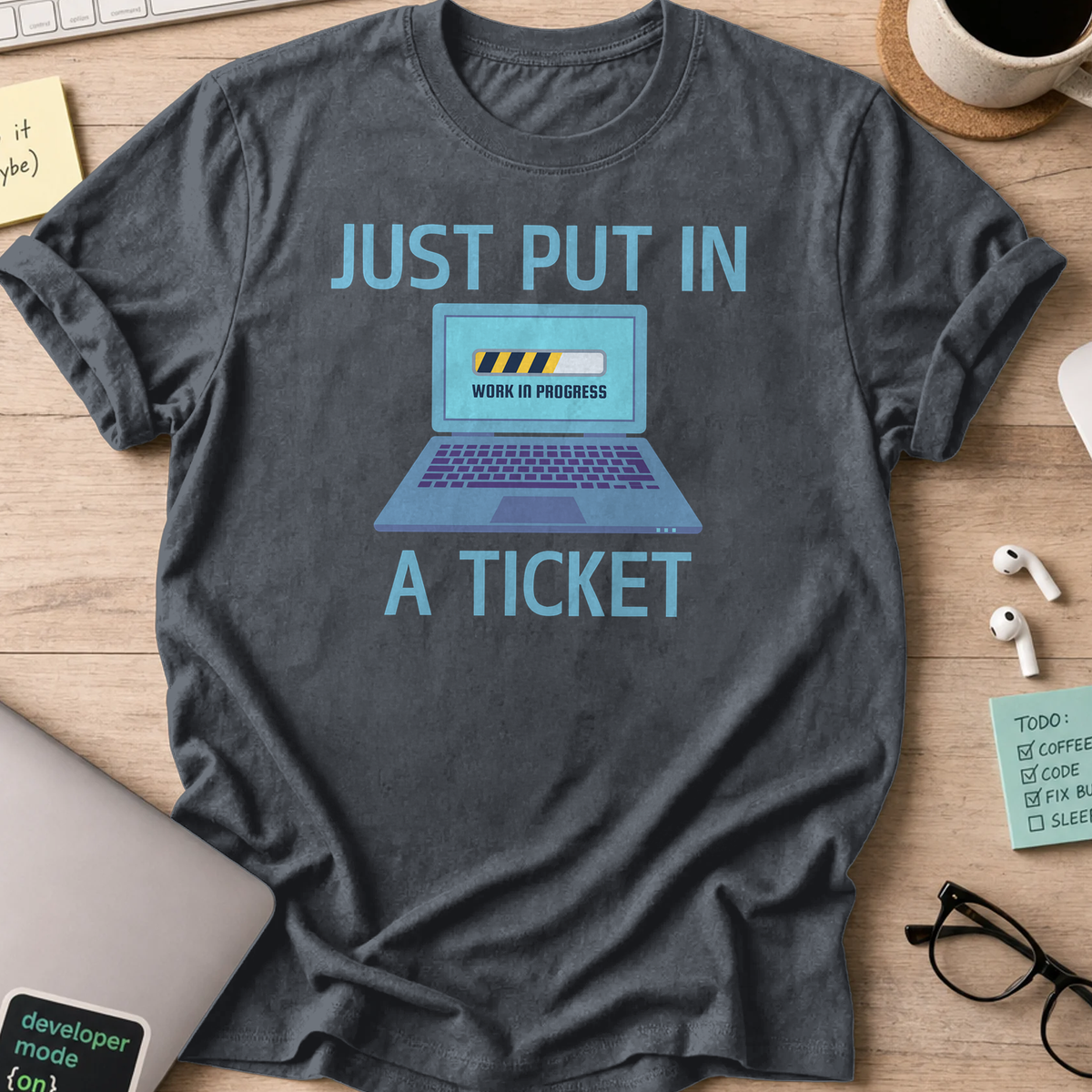 Dark Heather Grey devops shirt printed with "just put in a ticket", a funny programmer t-shirt and gift for DevOps and SRE engineers.