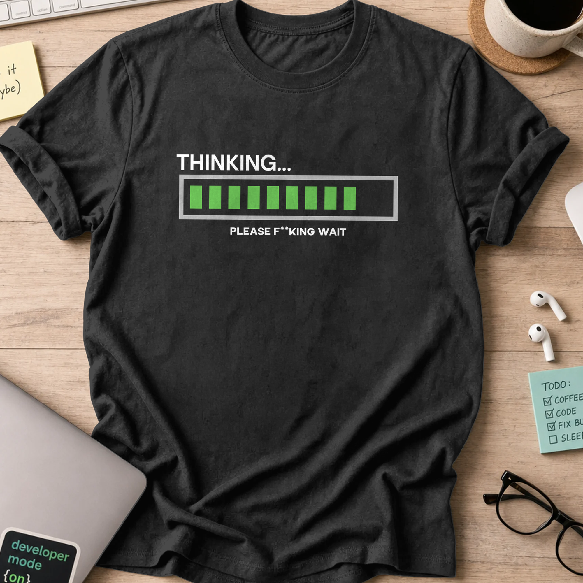 Black programmer shirt printed with "Thinking... Please wait", a funny developer t-shirt and coding gift for software engineers and coders.